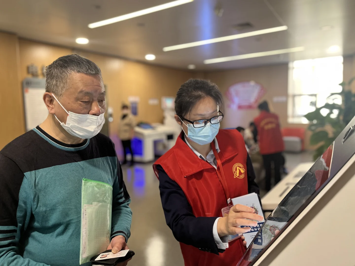 工作人员协助居民使用自助服务设备