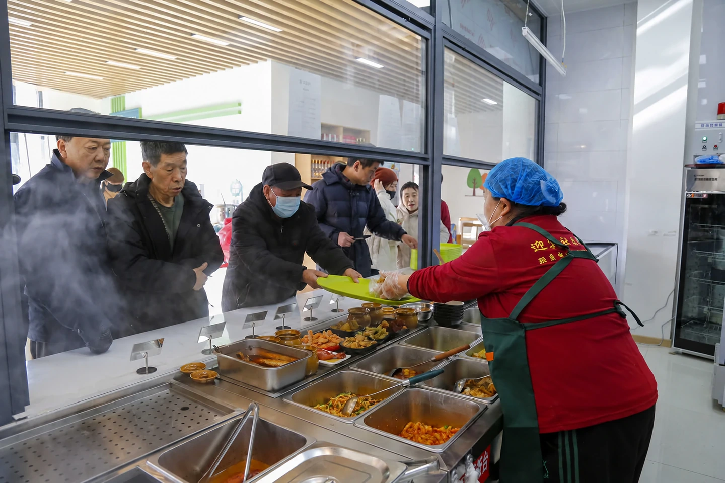 社区食堂工作人员为居民提供便民餐食